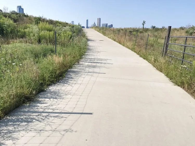 a hilly bike path with chicago in the distance.