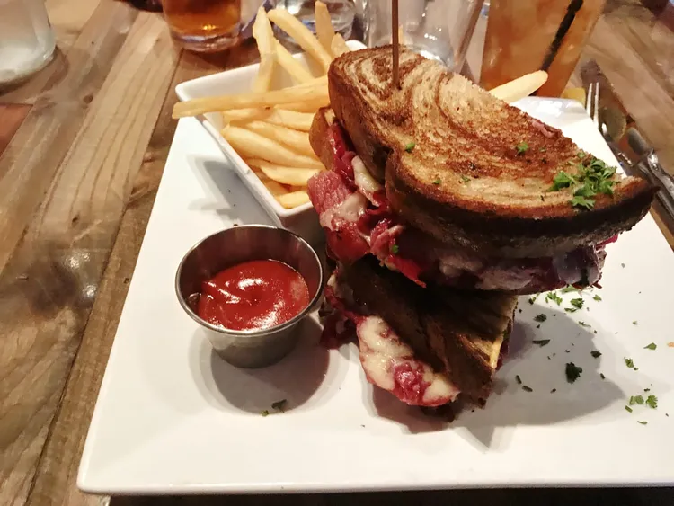 big pastrami snadwhich with fries and ketchup.