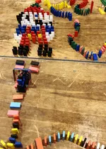 colorful dominos on a table ready to be toppled.