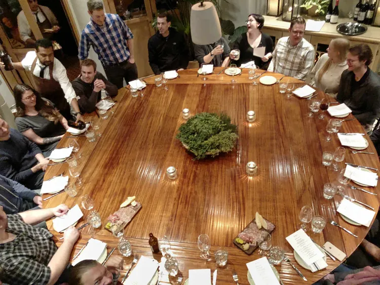 many people sitting on a round table.